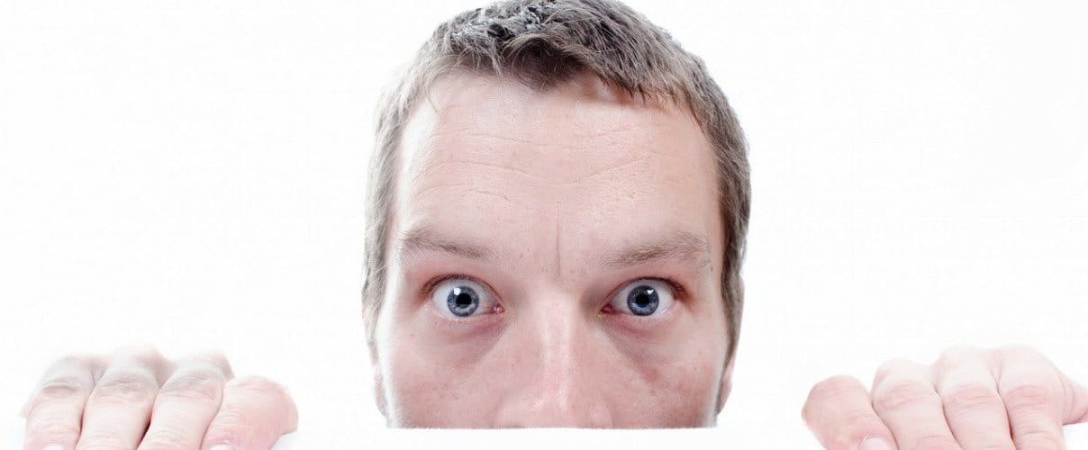 Slider Mann schaut ueber Tischkante