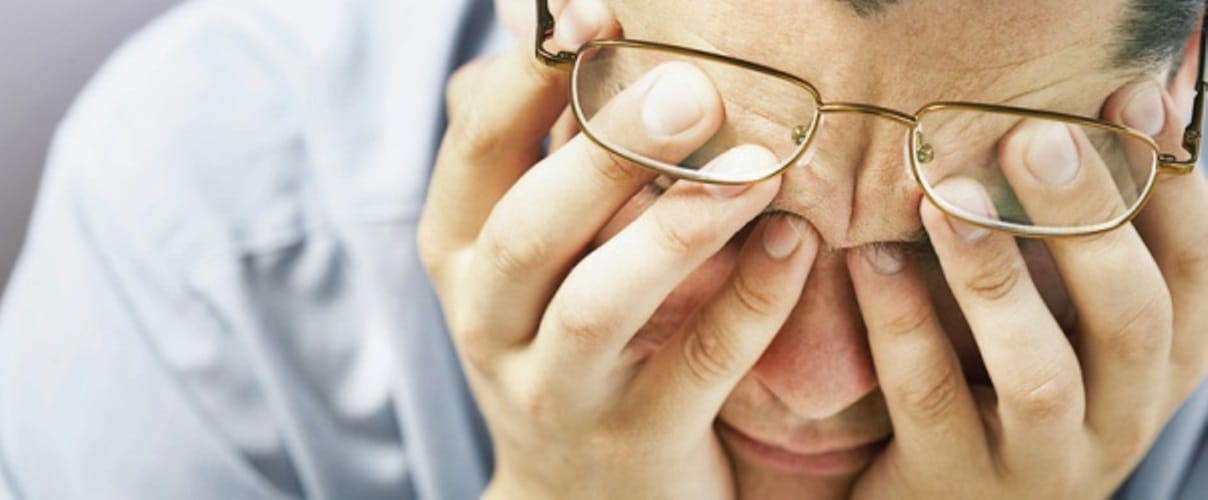 Mann mit Brille stützt Hände auf den Kopf Mann mit Brille stützt Hände auf den Kopf