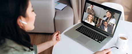 Frau vor Laptop mit virtuellem Team Frau vor Laptop mit virtuellem Team