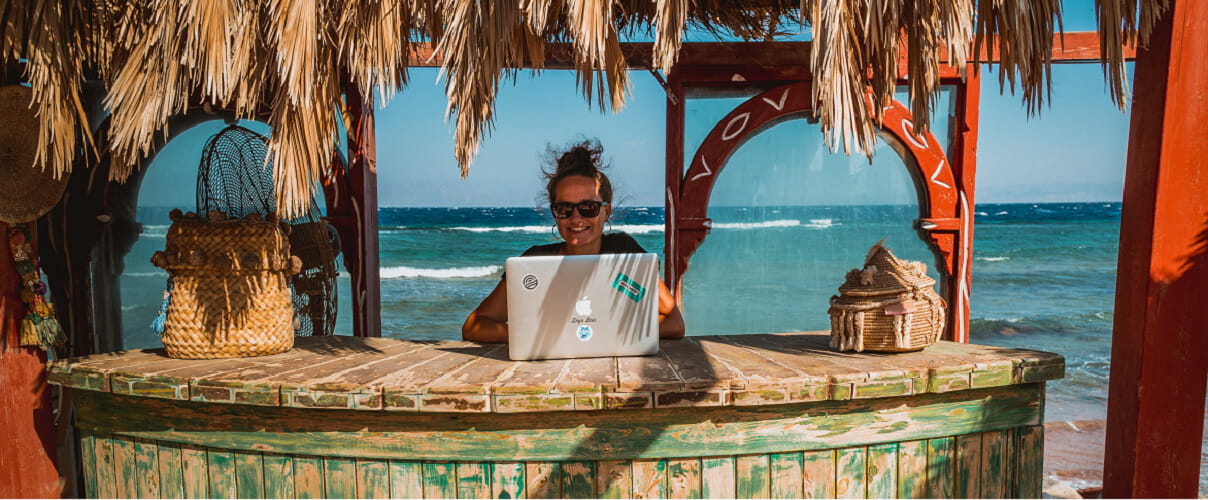 Frau mit Notebook an Beach Bar Frau mit Notebook an Beach Bar