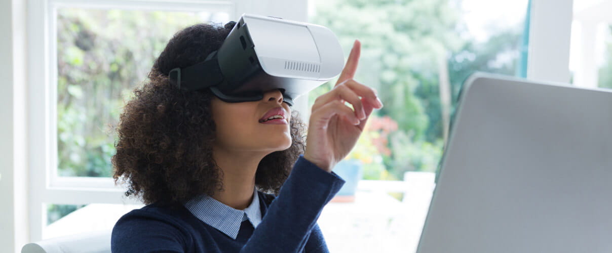 Frau mit Virtual-Reality-Brille vor Computer