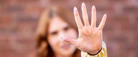 Frau streckt Handfläche nach vorne Frau streckt Handfläche nach vorne