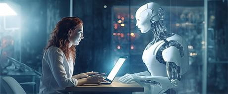 Frau vor Laptop sutzt gegenüber Roboter
