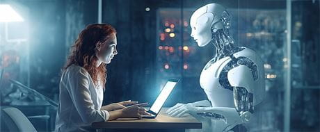 Frau vor Laptop sutzt gegenüber Roboter Frau vor Laptop sutzt gegenüber Roboter