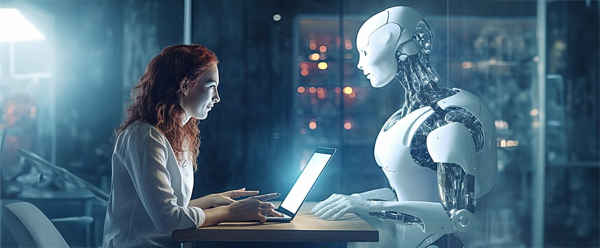 Frau vor Laptop sutzt gegenüber Roboter