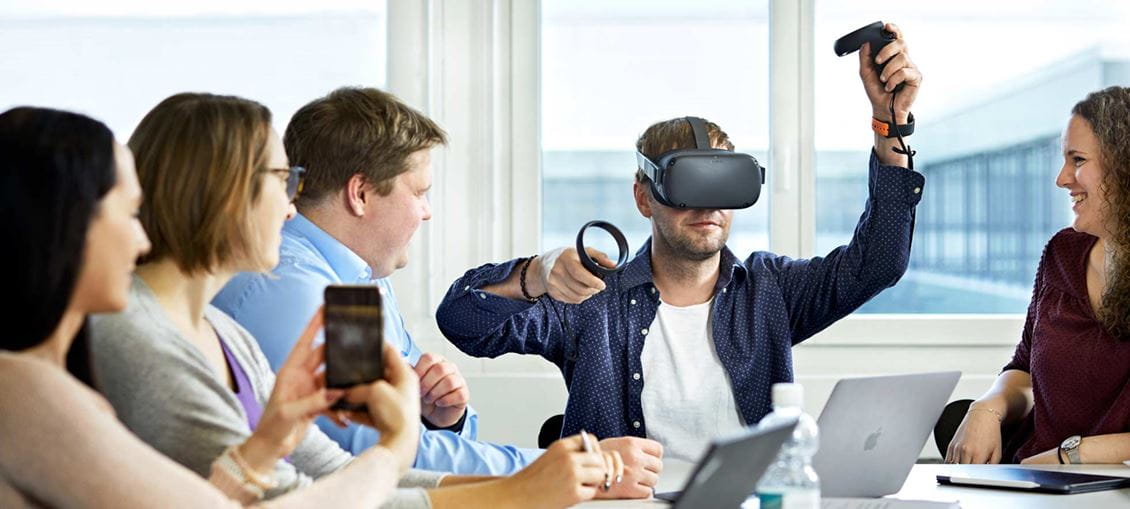 Mann mit VR-Brille und Zuschauern