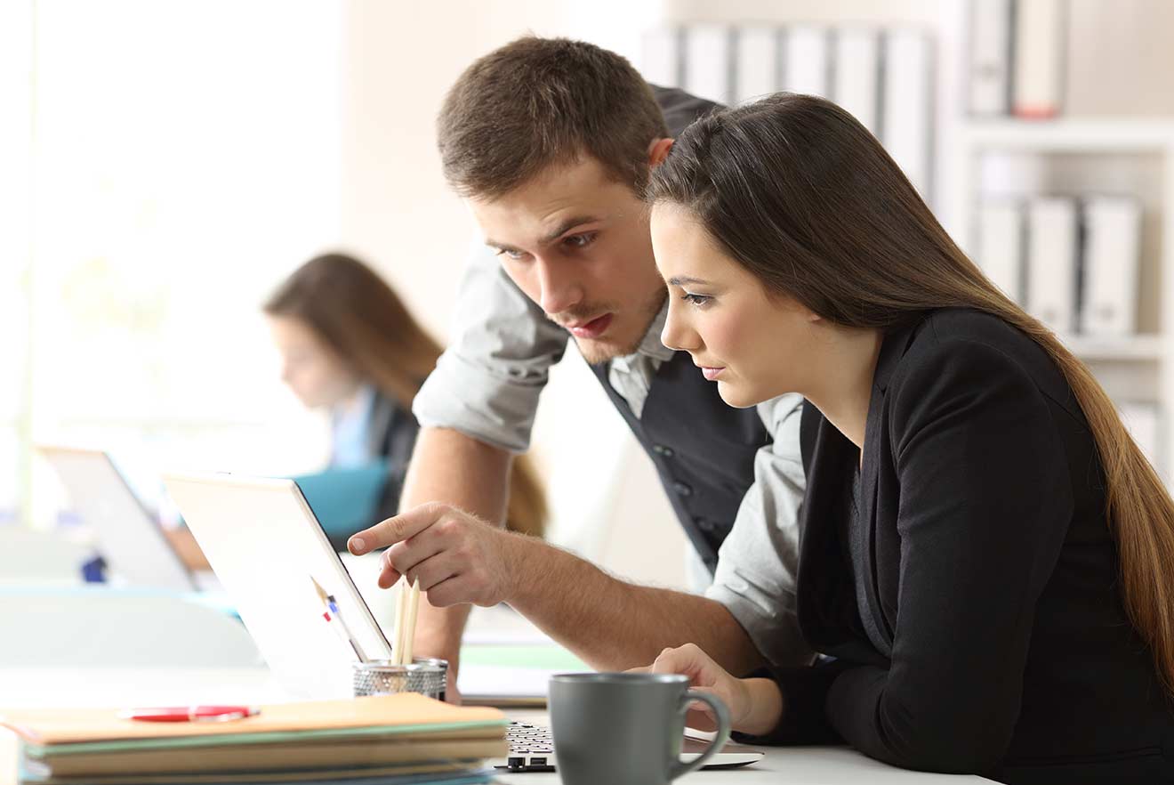 Zwei Studenten schauen auf Laptop