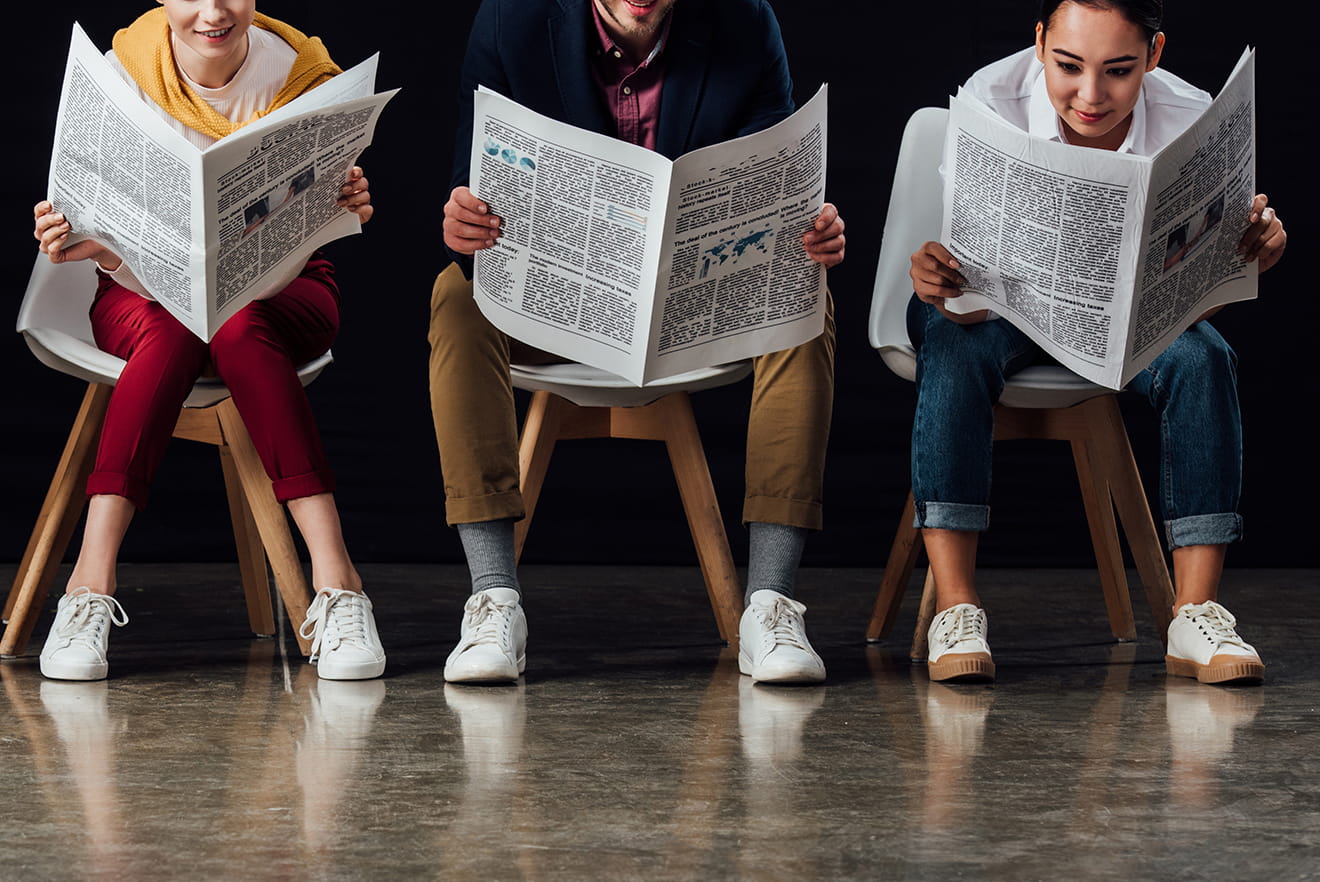 Menschen auf Stühlen lesen Zeitung