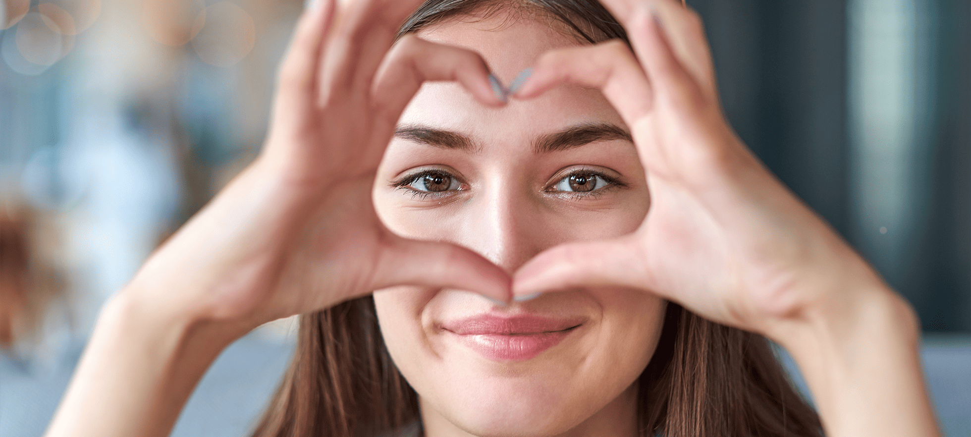 Frau schaut durch Herz