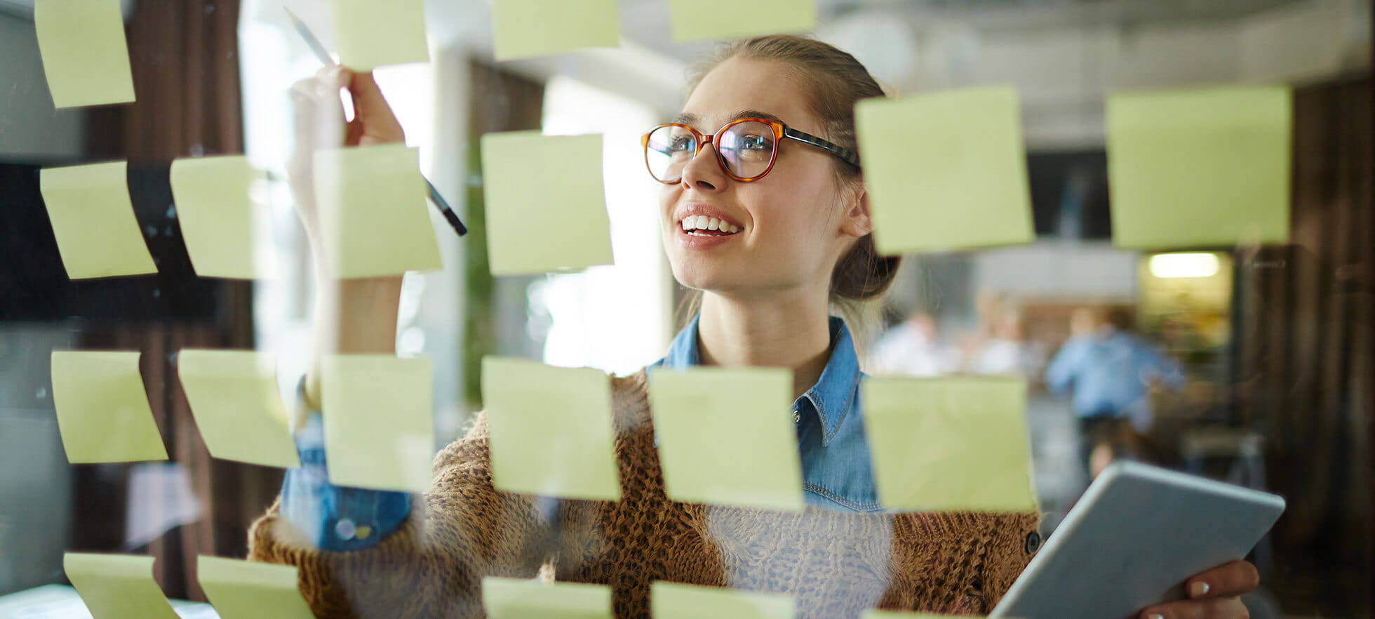 Junge Frau vor Post it Board