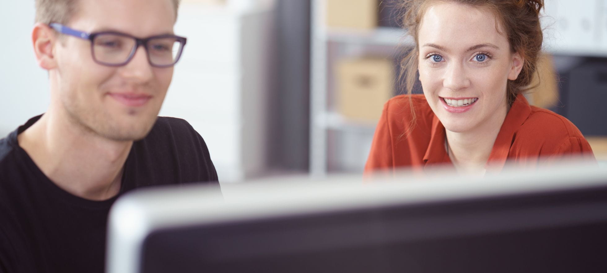 Mann und Frau vor Bildschirm