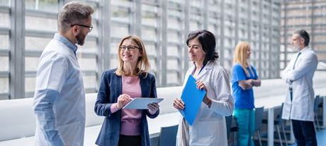 Verschiedene Berufsgruppen Health Professionals diskutieren im Spital, Shared Leadership