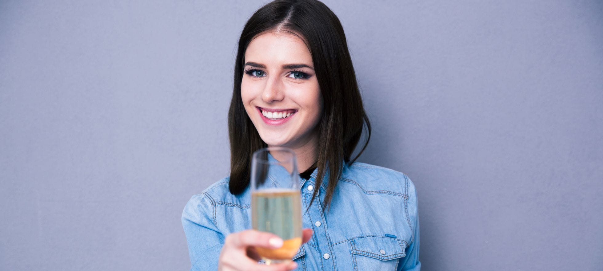 Symbolbild Diplomfeier, Frau prostet mit Glas 