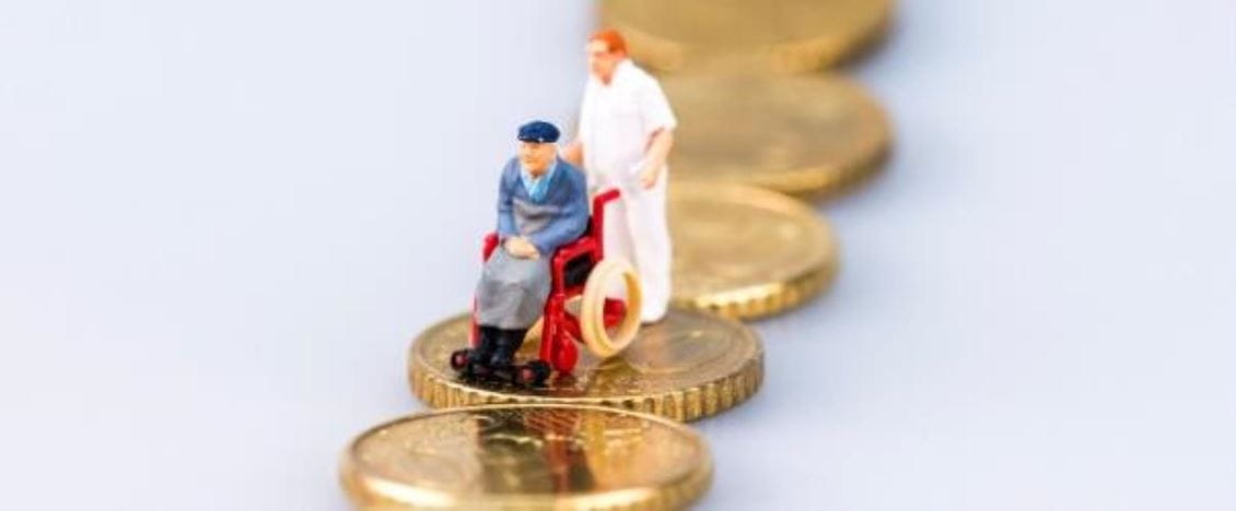 Rollstuhlfahrer mit Pfleger auf Geldmünze