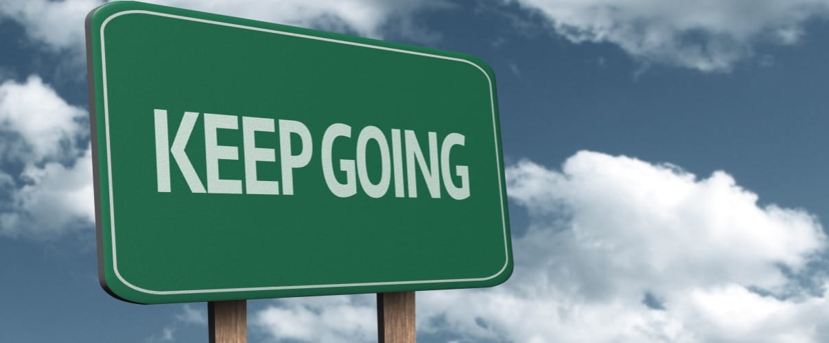 Schild Keep Going „Einfach immer Weitermachen" ist eher ein Anzeichen für Burnout-Gefährdung als für Resilienz