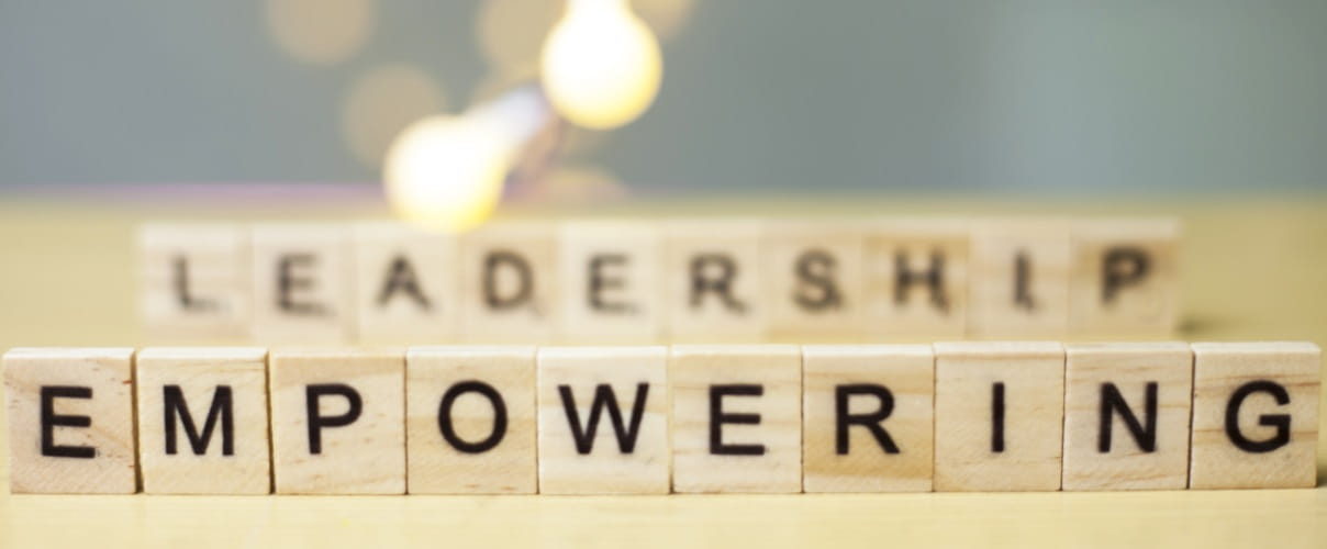 Scrabblesteine mit Wort Empowering Potential- und Kraftentfaltung steht im Mittelpunkt der Führungsarbeit.