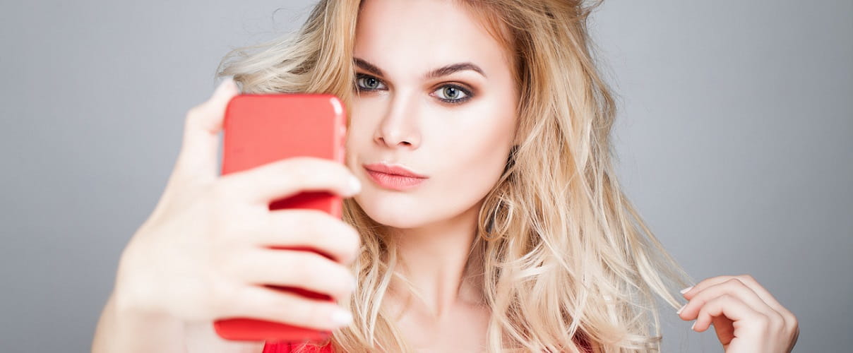 Junge blonde Frau macht Selfie